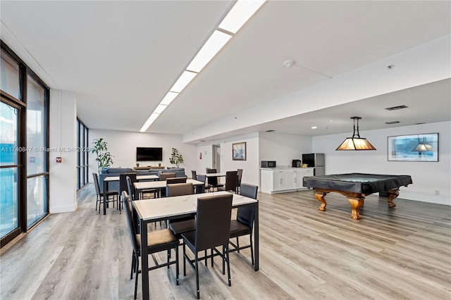 dining room featuring pool table, floor to ceiling windows, and light hardwood / wood-style flooring