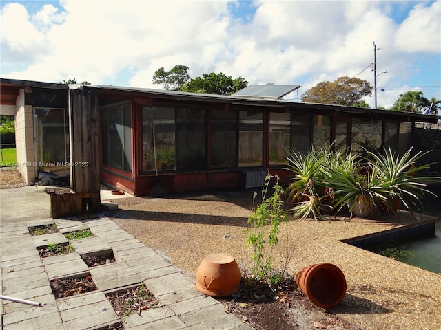 rear view of property featuring a sunroom