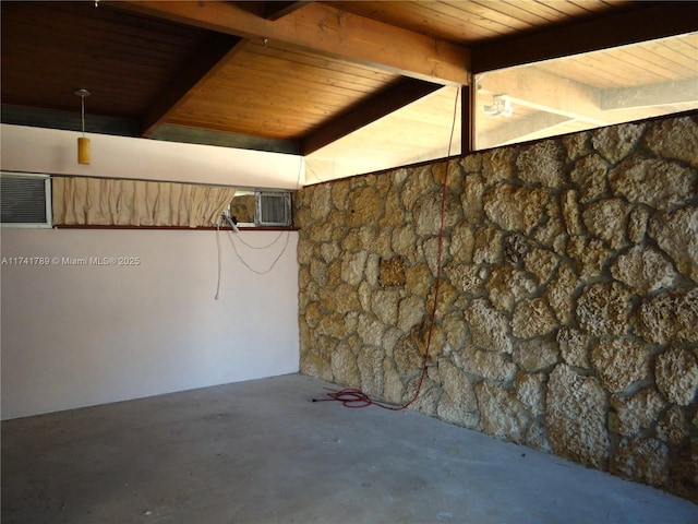 basement with wood ceiling and an AC wall unit