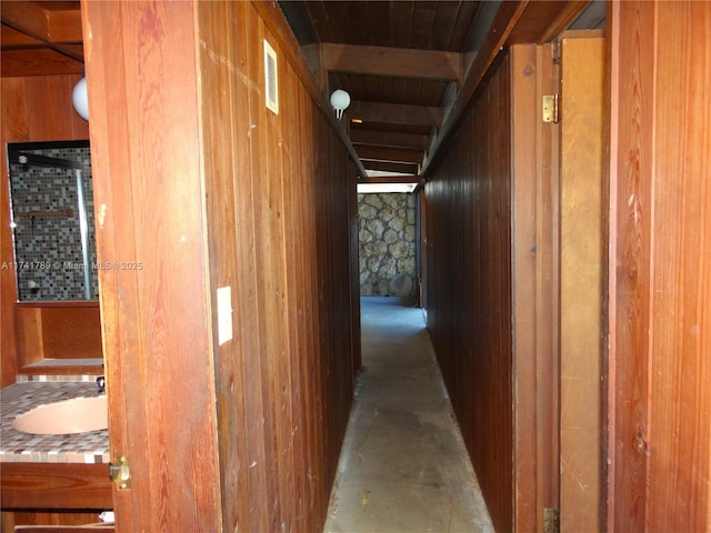 hall with sink and wooden walls