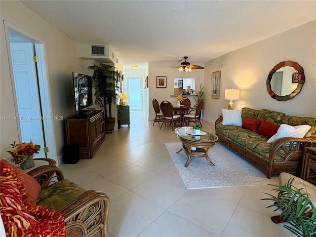 living area featuring ceiling fan and light tile patterned flooring