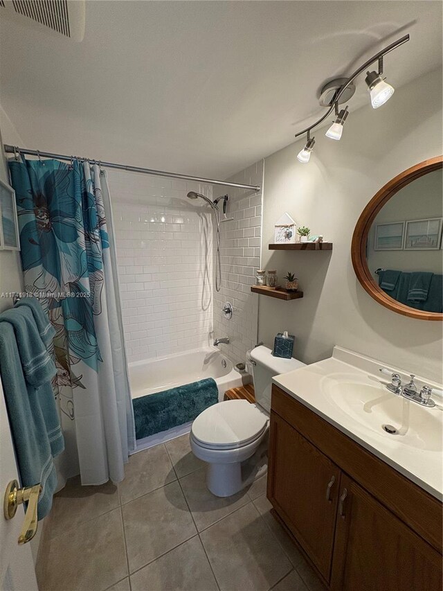 full bath with tile patterned flooring, toilet, vanity, and shower / tub combo