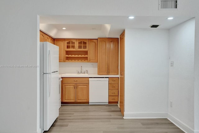 kitchen with sink, white appliances, and light wood-type flooring