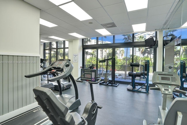 workout area with a wall of windows and a paneled ceiling