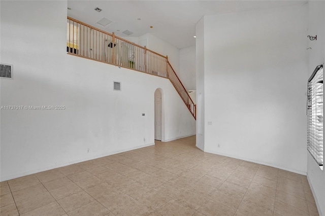 unfurnished living room with a high ceiling