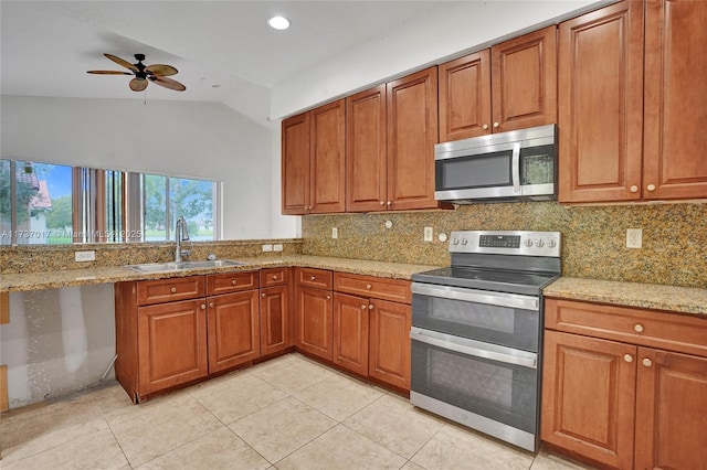 kitchen with appliances with stainless steel finishes, sink, and light stone counters