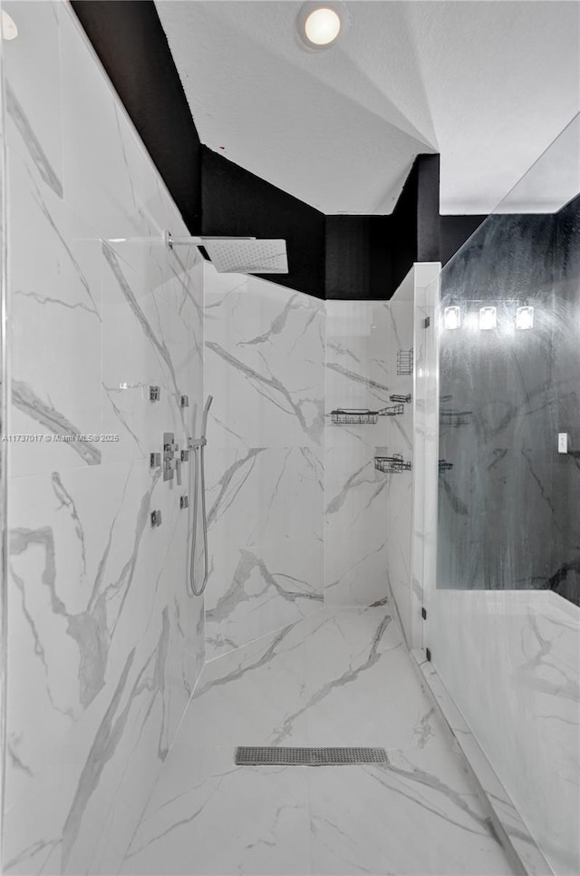 bathroom with a tile shower and a textured ceiling