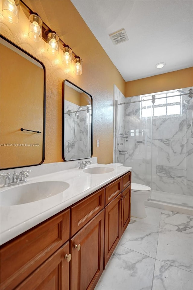 bathroom featuring vanity, toilet, and a shower with shower door