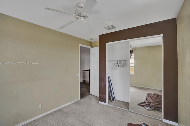 unfurnished bedroom with light colored carpet, ceiling fan, and a closet