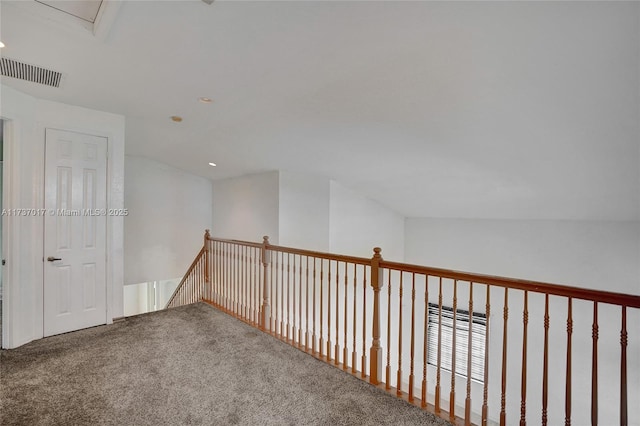 hall with vaulted ceiling and carpet flooring