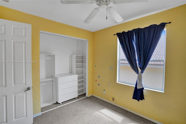 unfurnished bedroom with ceiling fan, carpet flooring, and a closet