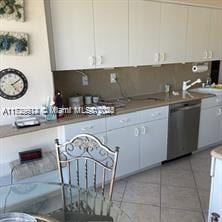 kitchen with white cabinetry, light tile patterned floors, and dishwasher