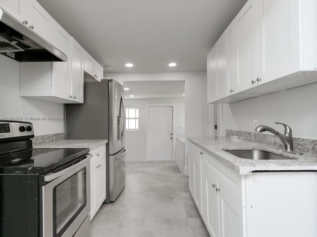 kitchen with sink, white cabinets, light stone counters, and stainless steel electric range