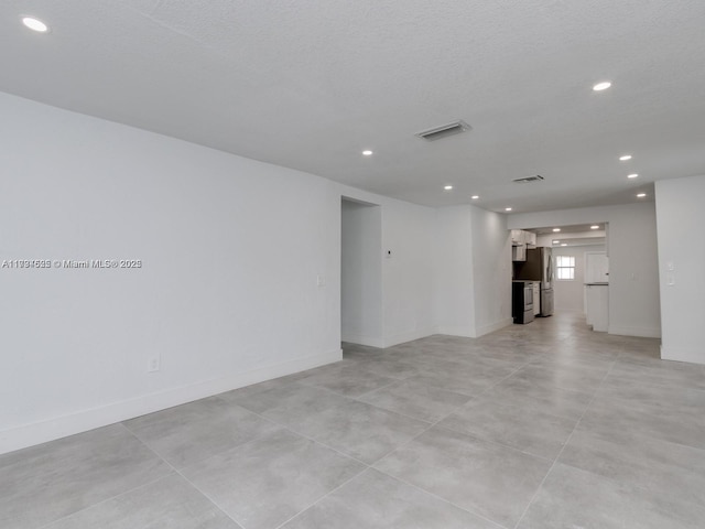 unfurnished room with a textured ceiling