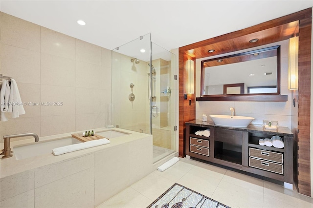 bathroom featuring tile patterned flooring, vanity, tile walls, and walk in shower