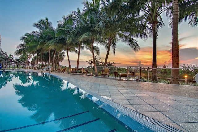 pool at dusk with a patio