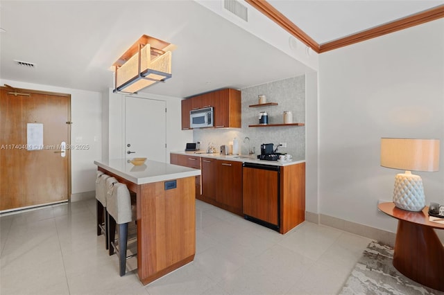 kitchen featuring a kitchen island, tasteful backsplash, a kitchen bar, crown molding, and paneled dishwasher