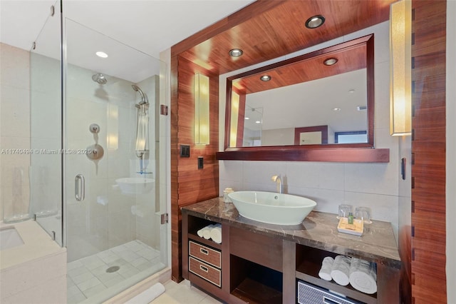 bathroom with tile walls, backsplash, vanity, a shower with door, and wooden ceiling