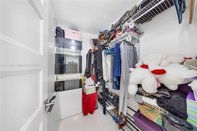 spacious closet with light tile patterned floors
