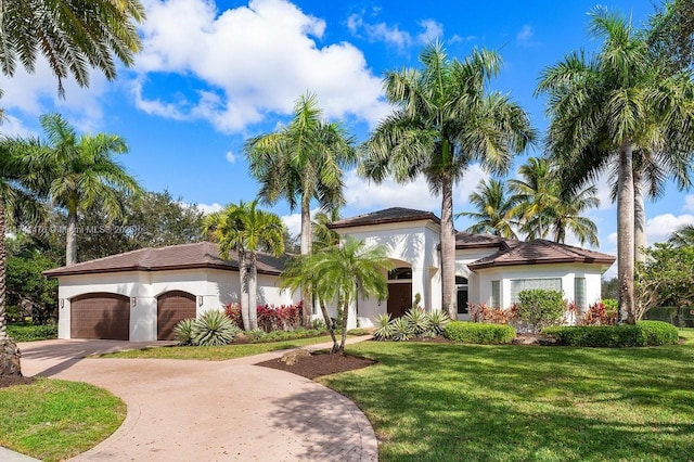 mediterranean / spanish home featuring a garage and a front yard