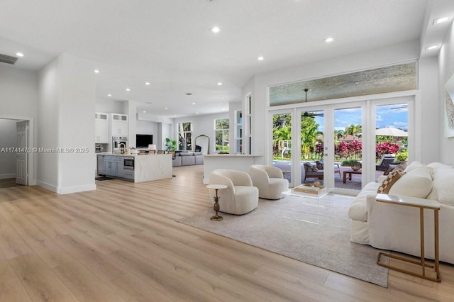 living room with french doors and light wood-type flooring