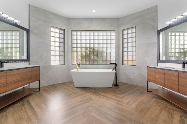 bathroom with parquet floors, a tub to relax in, and vanity