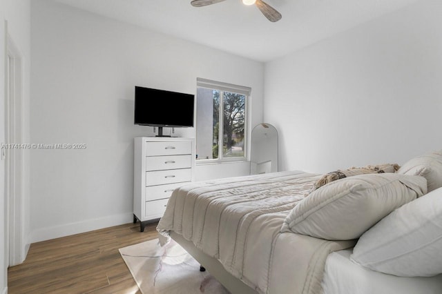 bedroom with dark hardwood / wood-style floors and ceiling fan