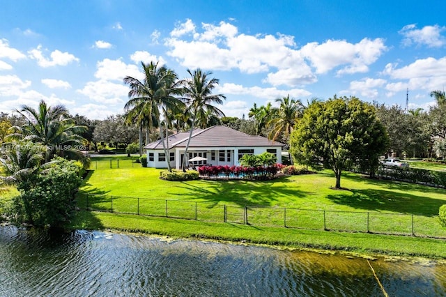 back of house featuring a water view and a yard