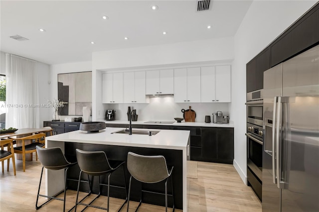 kitchen with white cabinetry, a kitchen island with sink, and stainless steel fridge with ice dispenser