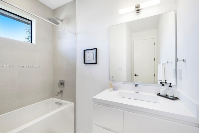 bathroom with tiled shower / bath combo and vanity