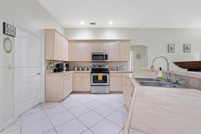 kitchen featuring visible vents, appliances with stainless steel finishes, light countertops, light brown cabinets, and a sink