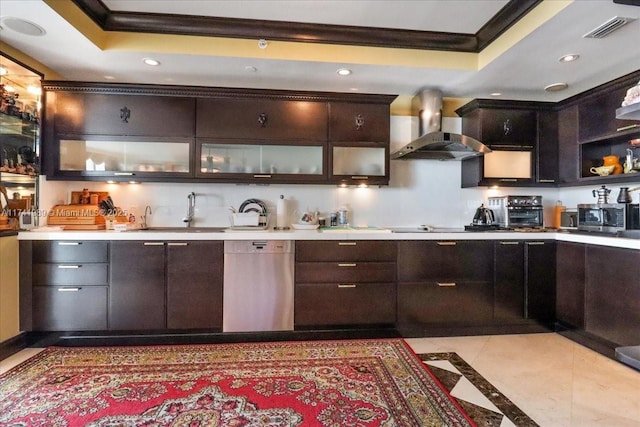 kitchen featuring a raised ceiling, wall chimney exhaust hood, appliances with stainless steel finishes, crown molding, and a sink