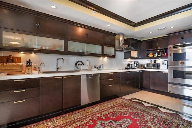 kitchen featuring a sink, light countertops, appliances with stainless steel finishes, wall chimney exhaust hood, and crown molding