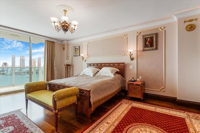 bedroom featuring access to exterior, a view of city, ornamental molding, and wood finished floors