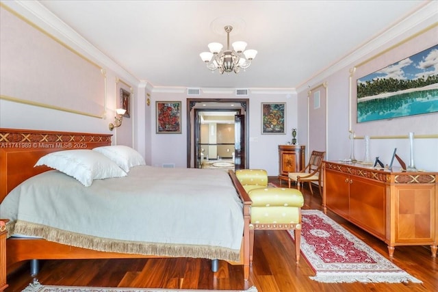 bedroom featuring a notable chandelier, visible vents, crown molding, and wood finished floors