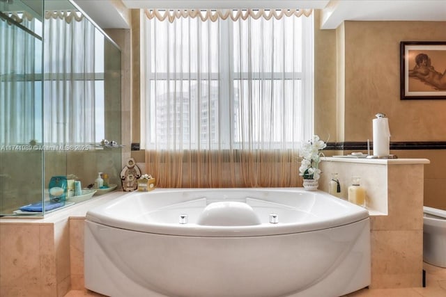 bathroom with a wealth of natural light and a garden tub