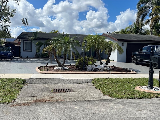 view of front facade featuring a garage, driveway, and stucco siding