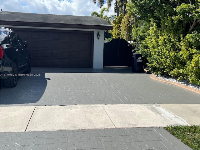 garage with decorative driveway