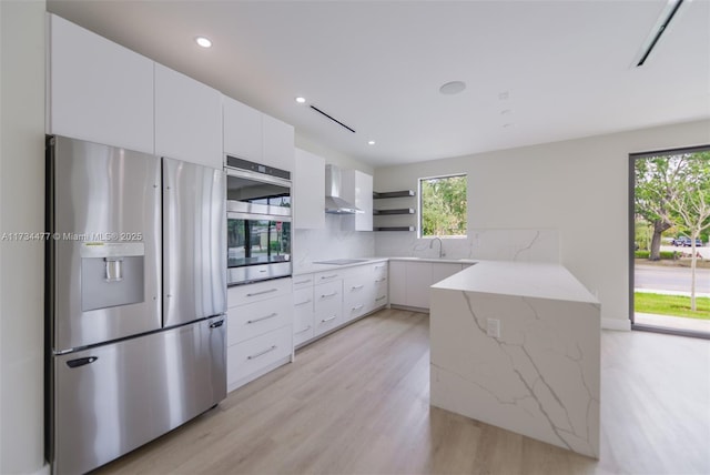 1617 NE 11th St Unit 1, Fort Lauderdale, FL 33304 - kitchen featuring appliances with stainless steel finishes, open shelves, modern cabinets, wall chimney exhaust hood, and light wood-type flooring