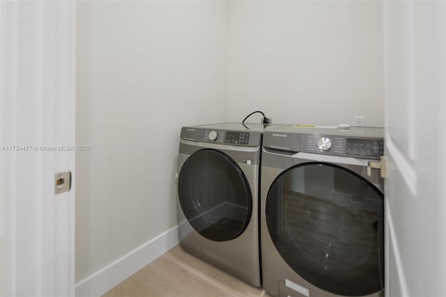1617 NE 11th St Unit 1, Fort Lauderdale, FL 33304 - washroom featuring independent washer and dryer, baseboards, and light wood-style flooring