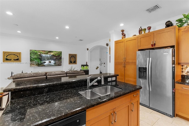 kitchen featuring stainless steel refrigerator with ice dispenser, light tile patterned flooring, sink, crown molding, and dark stone counters