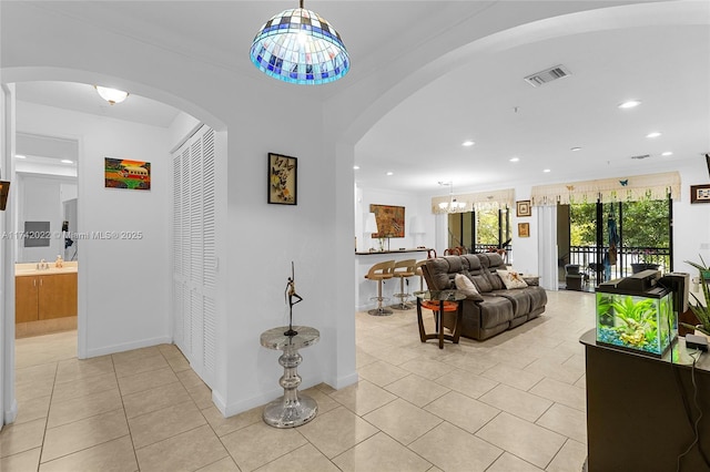 corridor with light tile patterned flooring, crown molding, and sink