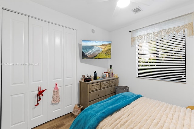 bedroom featuring hardwood / wood-style flooring, ceiling fan, and a closet