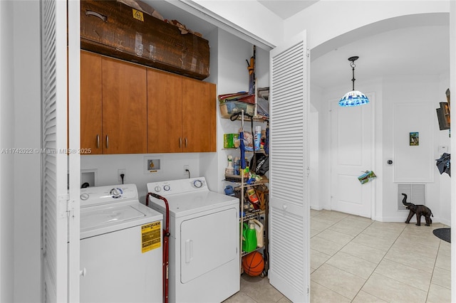 laundry area with cabinets, light tile patterned flooring, and independent washer and dryer