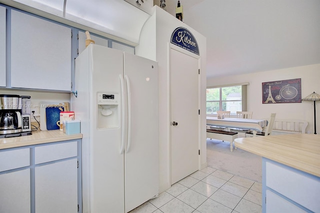 kitchen with light carpet, white fridge with ice dispenser, and white cabinets