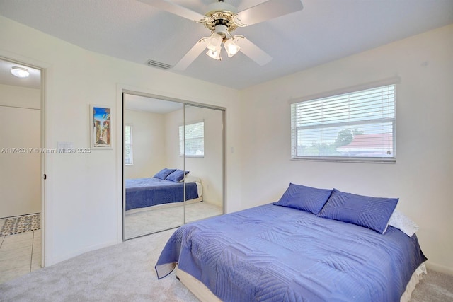 bedroom with light carpet, a closet, and ceiling fan