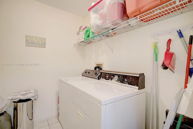 clothes washing area with washing machine and dryer and light tile patterned floors