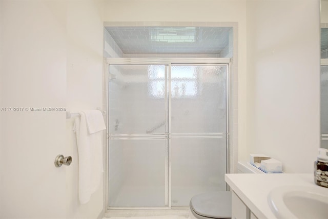 bathroom featuring an enclosed shower, vanity, and toilet