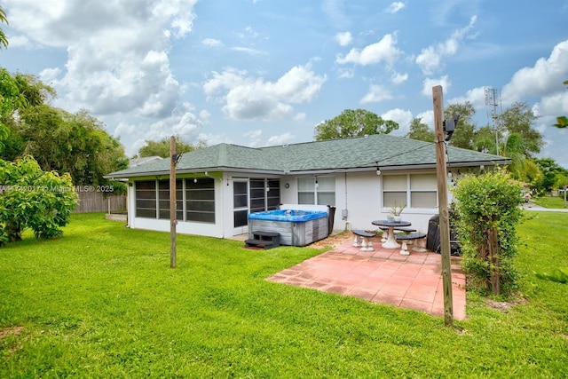 back of house featuring a hot tub, a patio, a sunroom, and a yard