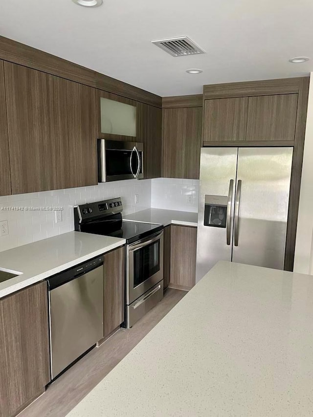 kitchen featuring stainless steel appliances and tasteful backsplash